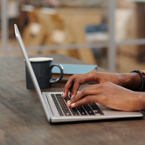 Hands typing on a laptop